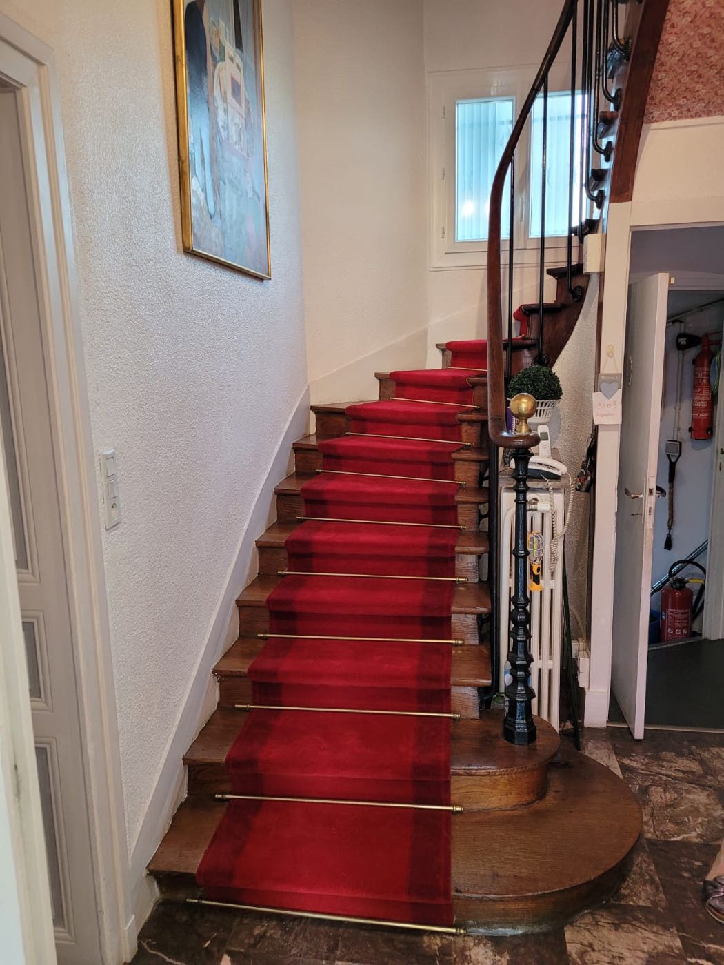 Escalier habillé d'un tapis rouge avec tringles laiton